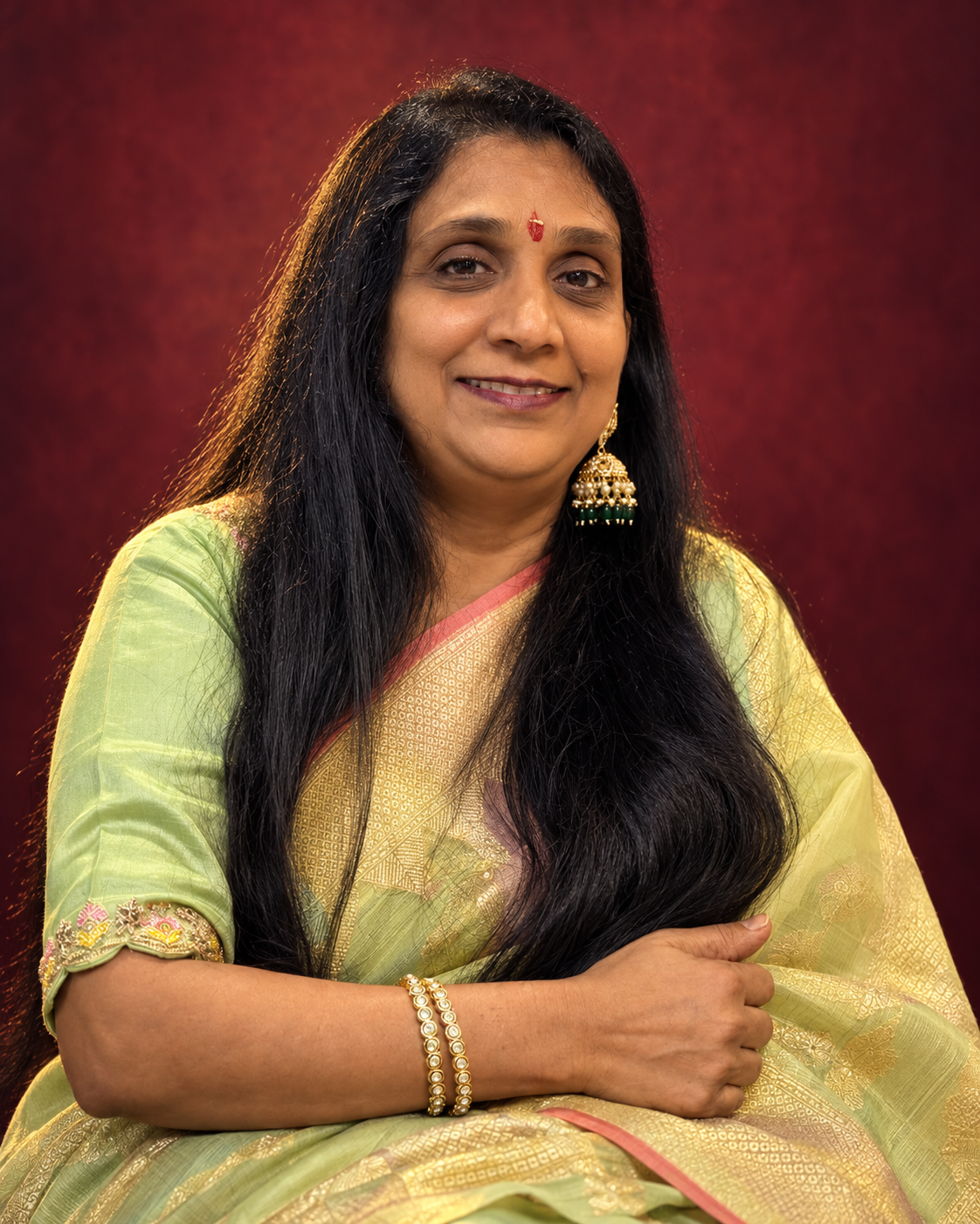 Portrait of Manju Rungta in a green and gold sari